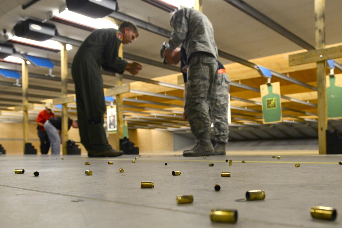 U.S. Airmen collect bullet casings upon the end of a beta test conducted at the firing range July 8, 2016, at Dyess Air Force Base, Texas. The beta test was part of an initiative to allow service members to bring their personal firearms to the base combat arms training and maintenance firing range. (U.S. Air Force photo by Airman 1st Class April N. Lancto/Released)