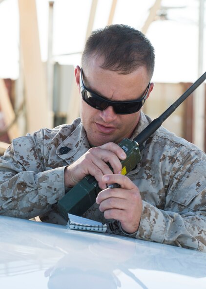 Marine Staff Sgt. Paul Prograis, Joint Terminal Attack Controller evaluator, radios information to his team members at Saylor Creek Range Complex, July 20, 2016. The Marines, visiting from Marine Corps Air Ground Combat Center Twentynine Palms, California, participated in Gunfighter Flag, a multi-national exercise. (U.S. Air Force photo by Senior Airman Malissa Lott/RELEASED)