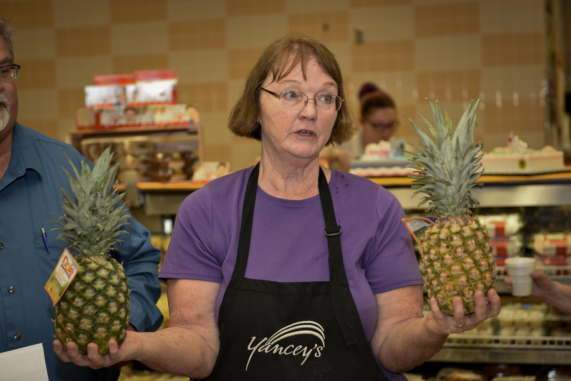 PETERSON AIR FORCE BASE, Colo. – Stephanie Boyle, Peterson Commissary merchandiser, talks with participants of the Fruit and Veggies – Eat More Tour about how to pick the sweetest pineapple at the commissary at Peterson Air Force Base, Colo., July 21, 2016. The tour was put on by the Peterson Health and Wellness Center and the commissary to educate Airmen about how to change up healthy eating options and better enjoy it. (U.S. Air Force photo by Senior Airman Rose Gudex)