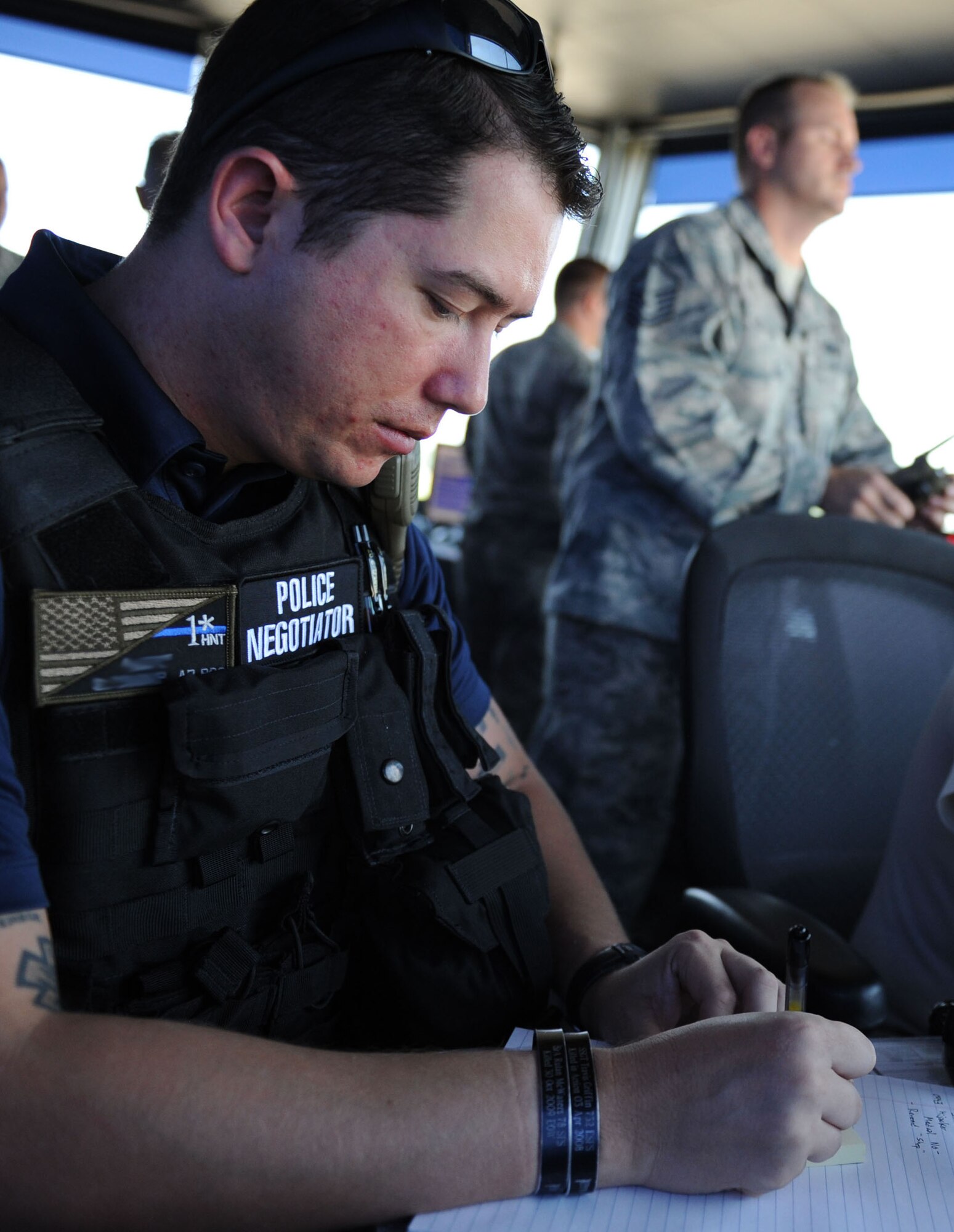 An 81st Security Forces Squadron police officer supervisor attempts to negotiate with a WC-130J Super Hercules “hijacker” during an anti-hijacking exercise on the flightline July 21, 2016, on Keesler Air Force Base, Miss. The exercise was used to test and maintain the ability of Keesler units to react and respond to developing situations. (U.S. Air Force photo by Kemberly Groue/Released)