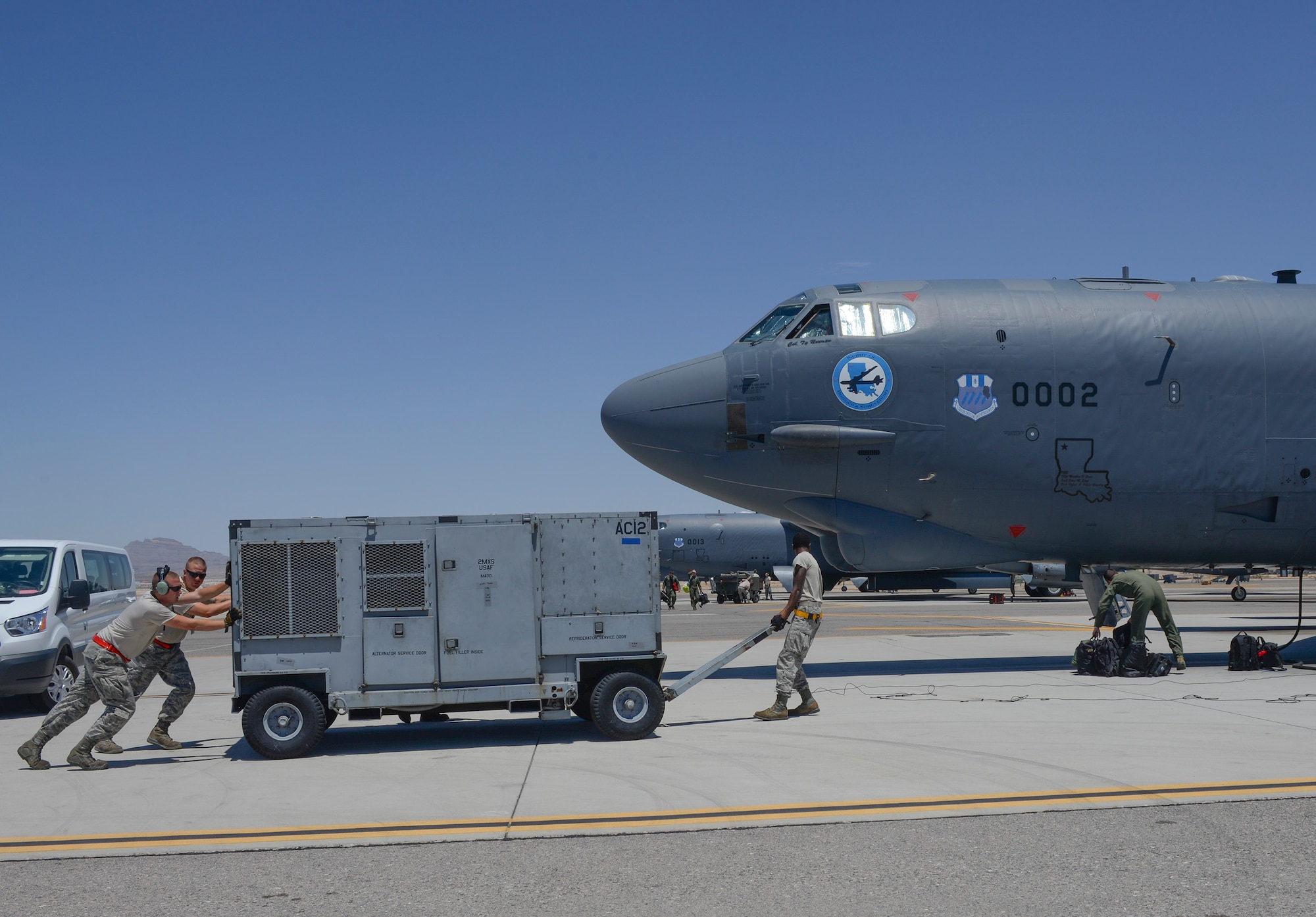 Crew chiefs from the 96th Bomb Squadron, Barksdale Air Force Base, La., move ground equipment to a B-52 Stratofortress prior to takeoff during Red Flag 16-3 at Nellis Air Force Base, Nev., July 18, 2016. Red Flag provides an opportunity for the 96th BS aircrew and maintainers the ability to hone their tactical skillsets in a challenging environment. (U.S. Air Force photo by Senior Airman Kristin High/Released)