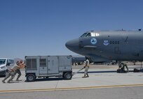 Crew chiefs from the 96th Bomb Squadron, Barksdale Air Force Base, La., move ground equipment to a B-52 Stratofortress prior to takeoff during Red Flag 16-3 at Nellis Air Force Base, Nev., July 18, 2016. Red Flag provides an opportunity for the 96th BS aircrew and maintainers the ability to hone their tactical skillsets in a challenging environment. (U.S. Air Force photo by Senior Airman Kristin High/Released)