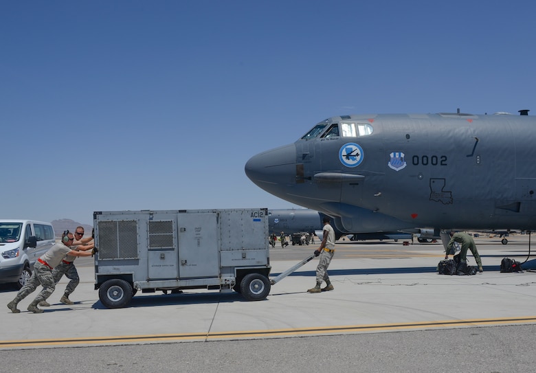 Crew chiefs from the 96th Bomb Squadron, Barksdale Air Force Base, La., move ground equipment to a B-52 Stratofortress prior to takeoff during Red Flag 16-3 at Nellis Air Force Base, Nev., July 18, 2016. Red Flag provides an opportunity for the 96th BS aircrew and maintainers the ability to hone their tactical skillsets in a challenging environment. (U.S. Air Force photo by Senior Airman Kristin High/Released)