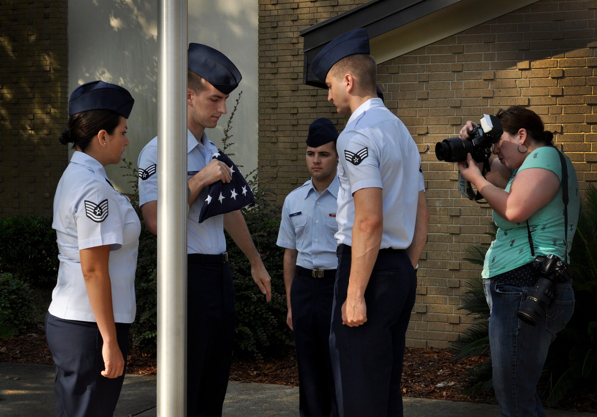 Tech. Sgt. Cassandra Cruz, 81st Force Support Squadron Airman Leadership School instructor, has her photo taken while instructing Airmen on flag folding at the ALS building, July 21, 2016, on Keesler Air Force Base, Miss. Cruz was selected as one of 2015’s 12 Outstanding Airmen of the Year. Volunteers assisted in providing staged photos of Cruz on the job for display in the Pentagon. (U.S. Air Force photo by Tech. Sgt. Kimberly Rae Moore/Released)