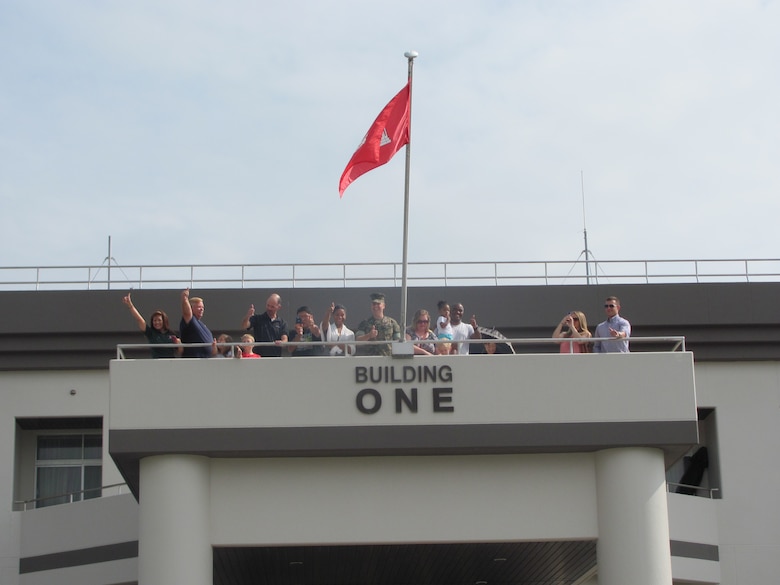 Passersby Marine Corps Air Station Iwakuni Building One on July 16 may have had to look twice when they saw the U.S. Army Corps of Engineer's bright red castle flag flying over the Marine headquarters.

Marine Col. Robert Boucher, commanding officer, MCAS Iwakuni, raised the USACE flag over the headquarters building with Lee Seeba, former resident engineer, Iwakuni Resident Office, under the joyful eyes of several Iwakuni Resident Office employees.

Boucher flew the engineer castle in Iwakuni as a "thank you" to the Corps' Iwakuni Resident Office for a job well done, after completing a particularly intricate project by deadline.

Bert Pechhold, current resident engineer, Iwakuni Resident Office, said the transformation that is occurring at MCAS Iwakuni could not be possible without the leadership and support from Boucher and his staff.

"This achievement symbolizes that spirit of cooperation and partnership between the Army and Marines," Pechhold said.

Seeba is currently the area engineer for the Japan District’s Okinawa Area Office.