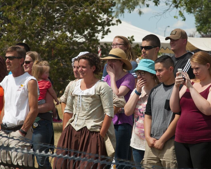 Spectators watch 90th Security Forces Squadron military working dog handlers as they show the law enforcement capabilities of the MWDs July 22, 2016, during Fort D.A. Russell Days, the annual F.E. Warren Air Force Base, Wyo., open house. MWDs can apprehend criminals and sniff out drugs or explosives. (U.S. Air Force photo by Senior Airman Jason Wiese)