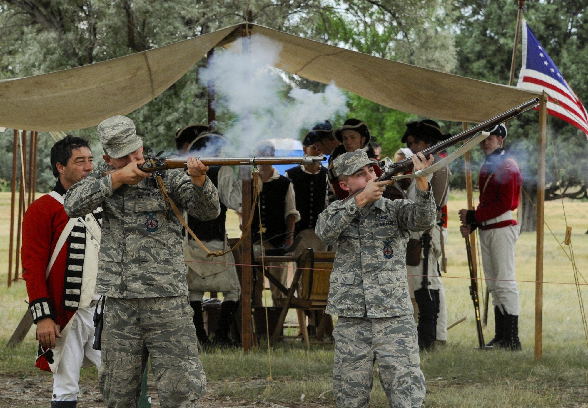 Senior Airman Logan Utt and Airman 1st Class Justin Clifford, 90th Civil Engineer Squadron firefighters, fire muskets brought to the annual F.E. Warren Air Force Base, Wyo., open house, Fort D.A. Russell Days, by members of Vision Heirs, an American Revolutionary War re-enactment group. Hands-on history presentations give people a glimpse into the past. (U.S. Air Force photo by Senior Airman Jason Wiese)