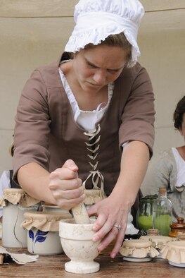 Rebecca Langemann, Vision Heirs re-enactment group surgeon's assistant and medical team leader, grinds comfrey leaves and water into a poultice to be used for wound tending July 22, 2016, during Fort D.A. Russell Days, the annual F.E. Warren Air Force Base, Wyo., open house. During the open house, the public is invited to learn about the history and mission of the base. (U.S. Air Force photo by Senior Airman Jason Wiese)