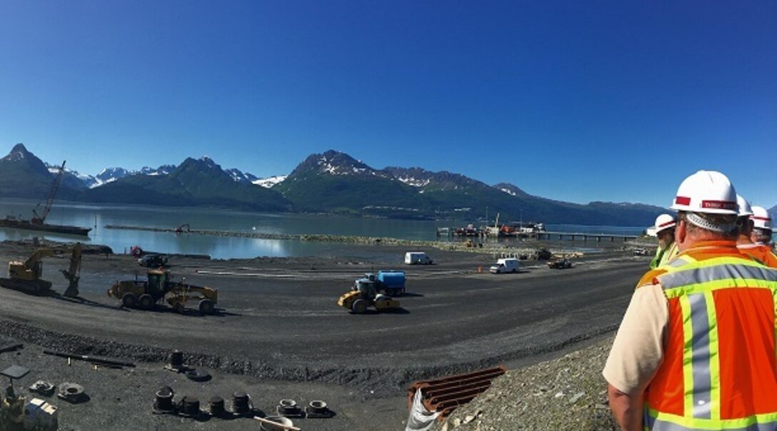The USACE Alaska District is constructing the foundation for a new breakwater from land during low tide at Valdez Harbor in Alaska. Once the base layer is in place, building from the water side will commence. Meanwhile, a dredge continues to excavate the harbor and navigation channels.