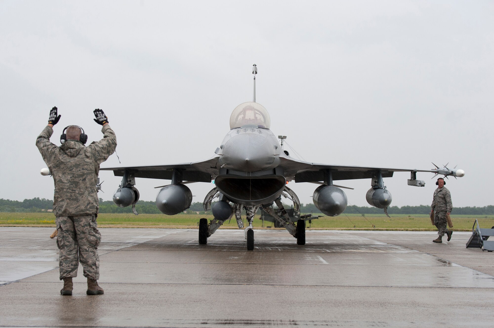 Master Sgt. John A. St. George, crew chief from the 140th Wing, Colorado Air National Guard, Buckley Air Force Base, Colorado, marshals an F-16 Fighting Falcon into position after landing at Papa Air Base, Hungary, while other crew chiefs chalk the wheels. This is the first time Colorado jets have landed in Hungary, and the first time the Colorado Air Guard has been to Europe in at more than 20 years. In support of Operation Atlantic Resolve, the 140th Wing, Colorado Air National Guard from Buckley Air Force Base, Colorado, has deployed approximately 200 Airmen to Papa Air Base, Hungary, to conduct familiarization training alongside our NATO ally, Hungary. They will also participate in cross-border training with other deployed U.S. forces' aircraft and NATO aircraft in the region. This deployment continues to demonstrate our commitment to our allies and European security and stability. (U.S. Air National Guard photo by Senior Master Sgt. John Rohrer) 
