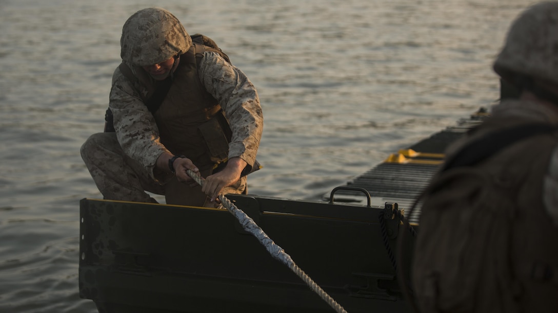 Marines with Bridge Company, 8th Engineer Support Battalion and Bridge Co. Bravo, 6th ESB tie an Improved Ribbon Bridge to a Mk3 bridge erection boat during Exercise River Assault on Fort Chaffee, Arkansas, July 18, 2016. The Marines spent two weeks operating Mk3 bridge erection boats practicing connecting all the IRBs in preparation for the final exercise, which was a continuous IRB spanned across the Arkansas River.