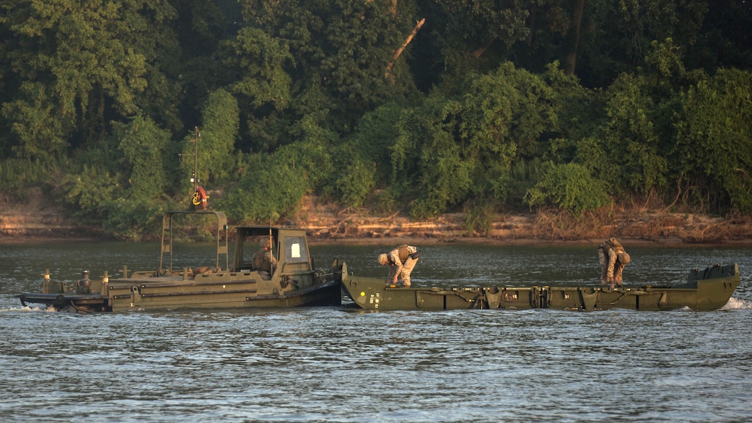 Marines with Bridge Company, 8th Engineer Support Battalion and Bridge Co. Bravo, 6th ESB prep an Improved Ribbon Bridges before connecting it to the continuous bridge during Exercise River Assault on Fort Chaffee, Arkansas, July 19, 2016. The Marines prepped and guided their IRBs upstream to where the U.S. Army 814th Multi-Roll Bridge Co. was constructing their portion of the continuous span.