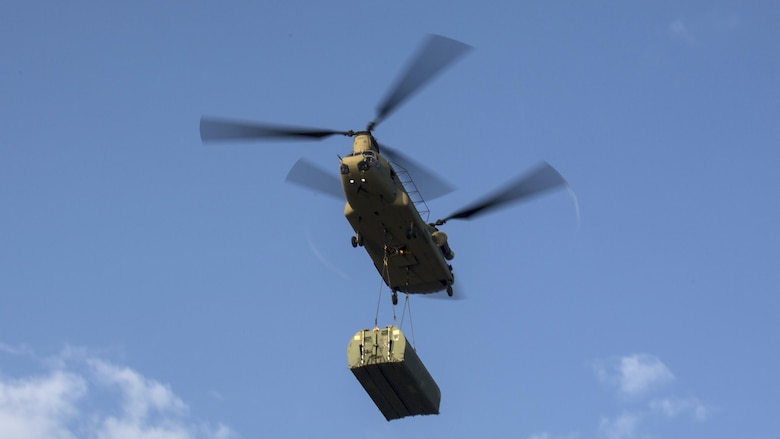 A CH-47 Chinook flies to the drop point with an Improved Ribbon Bridge during Exercise River Assault on Fort Chaffee, Arkansas, July 19, 2016. The Marines spent two weeks operating their Mk3 bridge erection boats and practicing connecting IRBs in preparation for the final exercise, which was a continuous IRB spanned across the Arkansas River.