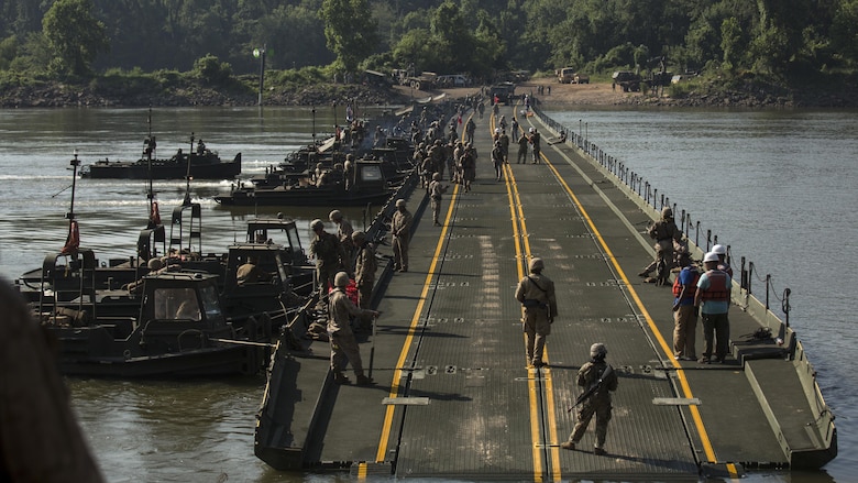Marines with Bridge Company, 8th Engineer Support Battalion, Bridge Co. Bravo, 6th ESB and U.S. Army soldiers with 814th Multi-Roll Bridge Co. begin allowing vehicles to cross the continuous span bridge during Exercise River Assault on Fort Chaffee, July 19, 2016. The Marines spent two weeks operating Mk3 bridge erection boats and practicing connecting IRBs in preparation for the final exercise, which was a continuous IRB spanned across the Arkansas River.