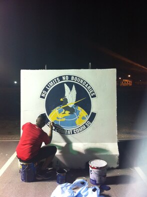 U.S. Air Force Reserve Master Sgt. Nichols Hermon, 55th Combat Communications Squadron, adding the finishing touches on the security barrier bearing the 55th CBCS emblem at an undisclosed deployed location in the Air Forces Central Command area of responsibility. Twelve Citizen Airmen  deployed recently and were afforded the opportunity to leave a lasting mark at the base to commemorate the work their time there. (U.S. Air Force courtesy photo) 
