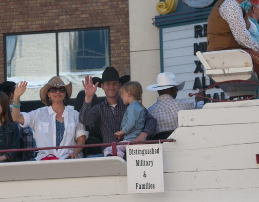 Chief Master Sgt. Matthew Wells, 20th Air Force command chief, and his family wave at the crowd during the 120th Cheyenne Frontier Days opening grand parade in Cheyenne, Wyo., July 23, 2016. Twentieth Air Force is responsible for the nation's three intercontinental ballistic missile wings and one nuclear operations support wing. (U.S. Air Force photo by Senior Airman Jason Wiese)