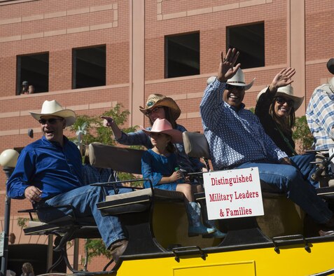 Twentieth Air Force and Task Force 214 commander, Maj. Gen. Anthony Cotton, and his wife, Mrs. Marsha Cotton, wave from a carriage with Col. Stephen Kravitsy, 90th Missile Wing commander, and his family, headed down Central Avenue in Cheyenne, Wyo., during the 120th Cheyenne Frontier Days opening grand parade July 23, 2016. (U.S. Air Force photo by Senior Airman Malcolm Mayfield)