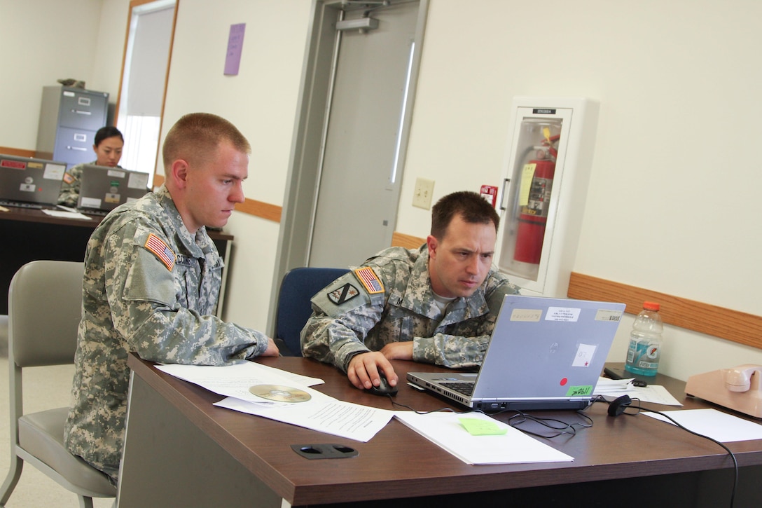 FT. MCCOY, Wisc. – Pfc. Michael McCune, left, and Staff Sgt. Kiefer Maddex look over the Integrated Computerized Deployment Execution System to ensure proper cargo placement on the vessel as part of their scenario in Trans Warrior held July 9 through July 23, here. Trans Warrior provides U.S. Army Reserve transportation Soldiers an opportunity to train realistically on port operations. (U. S. Army Reserve photo by Sgt. Charlotte Fitzgerald, 345th Public Affairs Detachment)