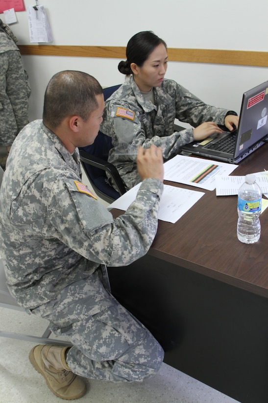 FT. MCCOY, Wisc. – Sgt. Wirad Sajjawerawan, left, and Pfc. Minsun Kim, members of the 931st Expeditionary Theatre Opening Element based out of Sherman Oaks, Calif., review the cargo movement scenario given to them as part of the Trans Warrior exercise, held here July 9 through 23. Trans Warrior provides U.S. Army Reserve transportation Soldiers an opportunity to train realistically on port operations. (U. S. Army Reserve photo by Sgt. Charlotte Fitzgerald, 345th Public Affairs Detachment)