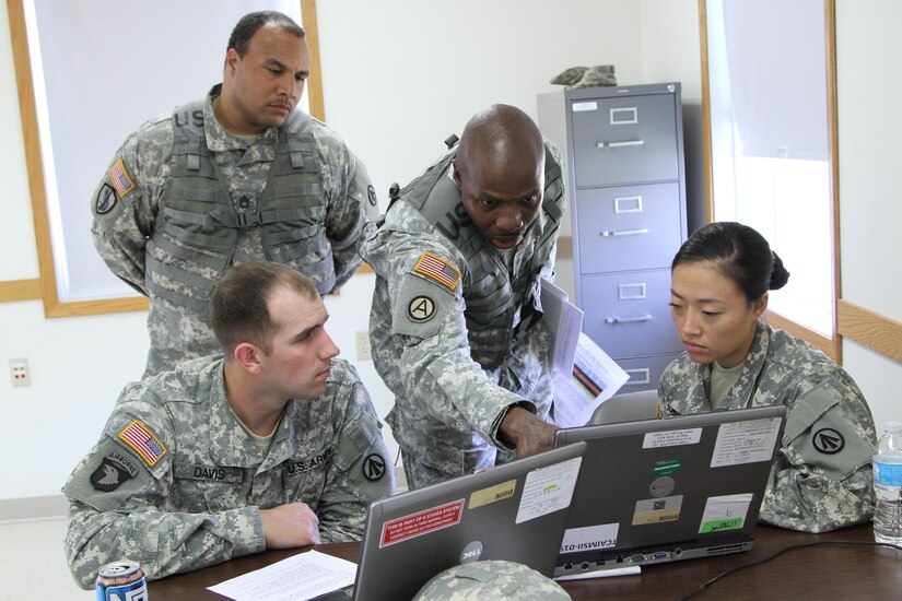 FT. MCCOY, Wisc. – Master Sgt. Duane Emerson, center, and Sgt 1st Class William Thomas, left back, Observer/Controller/Trainers for the Trans Warrior exercise, look over a scenario given in Transportation Coordinators’ Automated Information for Movement System II with Sgt. Andrew Davis, far left, and Spc. Jiuen Jun, members of the 931st Expeditionary Theatre Opening Element, based out of Sherman Oaks, Calif.. Trans Warrior was held July 9 through 23, here, providing U.S. Army Reserve transportation Soldiers an opportunity to train realistically on port operations. (U. S. Army Reserve photo by Sgt. Charlotte Fitzgerald, 345th Public Affairs Detachment)