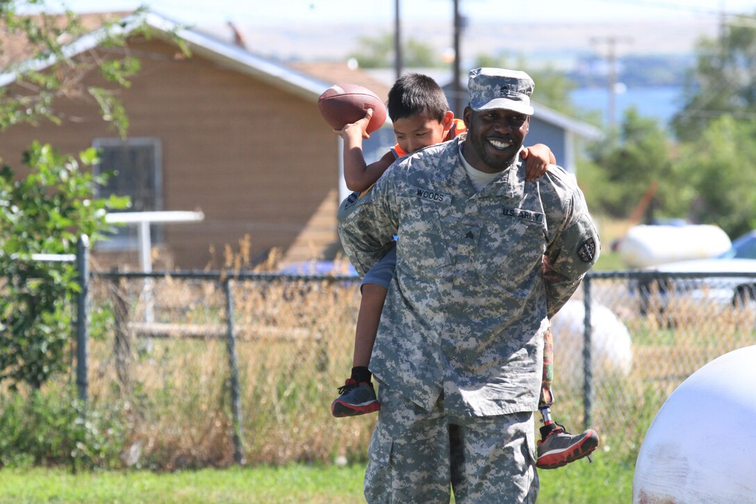 LOWER BRULE RESERVATION – Sgt. John Woods, a dental assistant from the Army Reserve’s 7233rd Medical Support Unit in Birmingham, Ala., gives a piggy-back ride to a local child from the Lower Brule Indian Reservation located 61 miles south of Pierre, S.D. July 19, 2016. Innovative Readiness Training brought Woods to the area where his unit is assisting the local health clinic with various medical services. He, along with three other Soldiers made a special trip to the Lower Brule Boys and Girls Club to teach children about proper dental hygiene.  IRT allows soldiers to sharpen their Army skills by using them in real-world situations. (U.S. Army Reserve photo by Spc. David Alexander)
