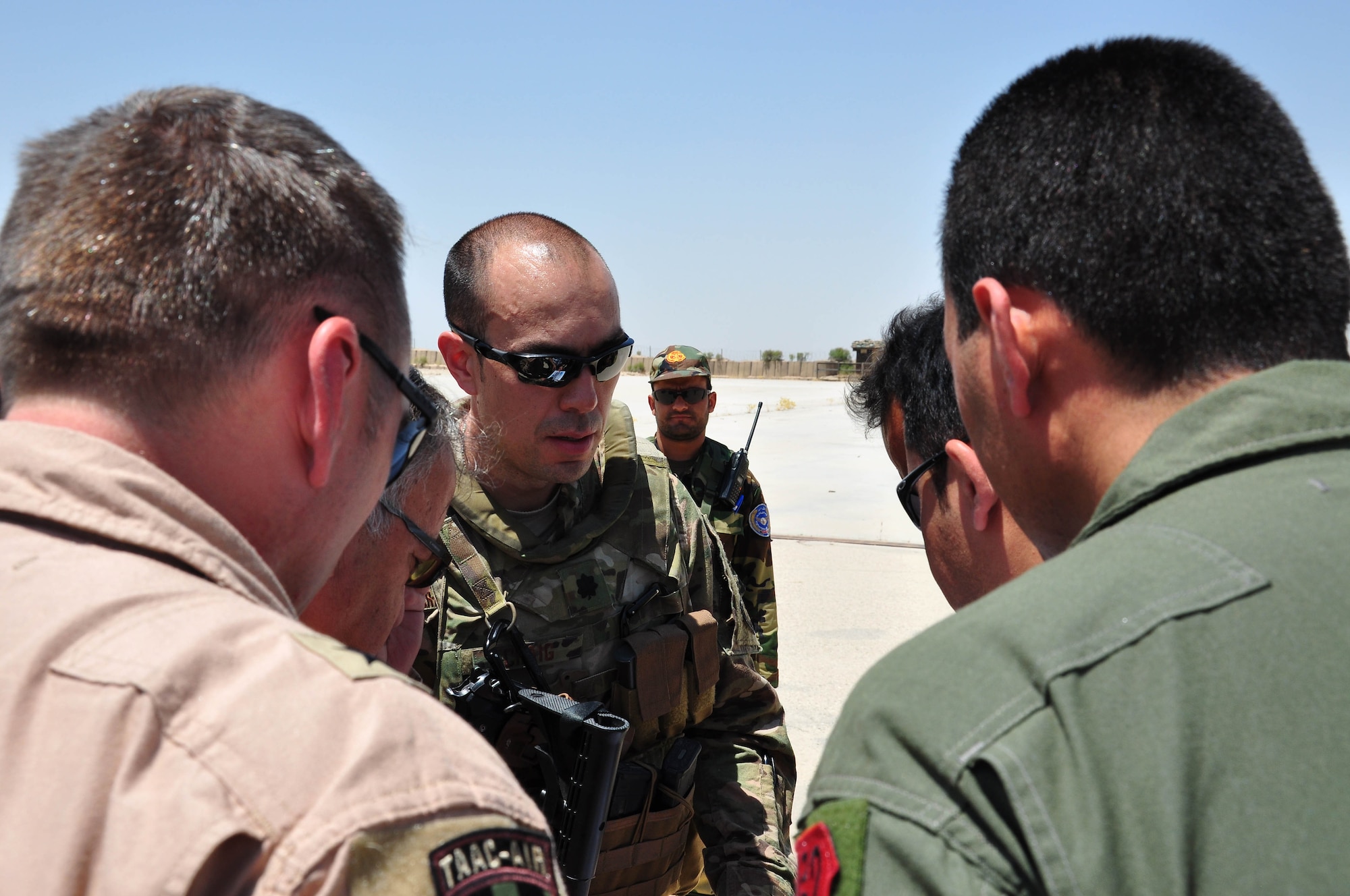 Lt. Col. Dan Craig, Train, Advise, Assist Command – Air (TAAC-Air) engineer, briefs Brig. Gen. David Hicks, 438th Air Expeditionary Wing and TAAC-Air commander, and Afghan Air Force Commander Lt. Gen. Abdul Wahab, during a visit to Mazar-e-Sharif, Afghanistan, July 21, 2016. Craig took the group to look at aircraft ramp projects in support of future AAF operations. (U.S. Air Force photo by Capt. Jason Smith) 