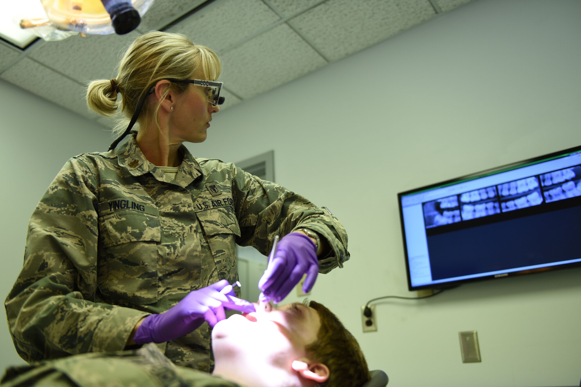 Maj. Nicole Yingling, 193rd Special Operations Wing Medical Group dentist, examines an Airman’s teeth during a routine dental check-up at the wing's Middletown, Pennsylvania, location. The wing’s flying mission annually requires more than 250 flight physicals and more than 800 occupational health exams be conducted by medical group personnel. (U.S. Air National Guard photo by Senior Airman Ethan Carl/Released)