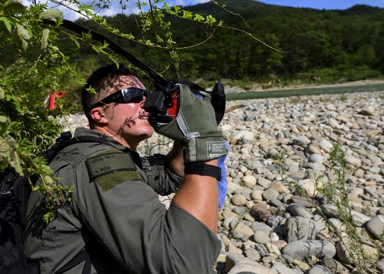 First Lt. Sky Lesh, 25th Fighter Squadron pilot, operates an emergency radio while waiting for an Air Force rescue team to pick him up during Exercise Pacific Thunder 16-2 in the Republic of Korea, July 19, 2016. This two-week long exercise is designed to train and validate tactics, techniques and procedures for combat search and rescue and air suppression of enemy defenses. Lesh acted as a downed pilot for a combat search and rescue training mission, involving rescue personnel deployed here from other Pacific Air Forces units working with Team Osan. This photo has been edited for privacy reasons. (U.S. Air Force photo illustration by Senior Airman Victor J. Caputo/Released)