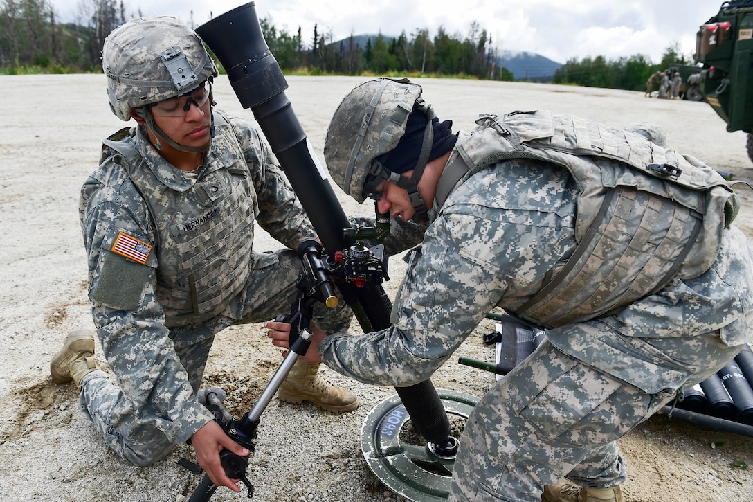 Army Pfc. Camill Hernandez, left, and Spc. Caleb Clark prepare to fire an 81 mm mortar during Arctic Anvil 2016 in the Yukon training area near Fort Wainwright, Alaska, July 23, 2016. Hernandez and Clark are assigned to the 25th Infantry Division’s 1st Stryker Brigade Combat Team, Alaska. Air Force photo by Justin Connaher