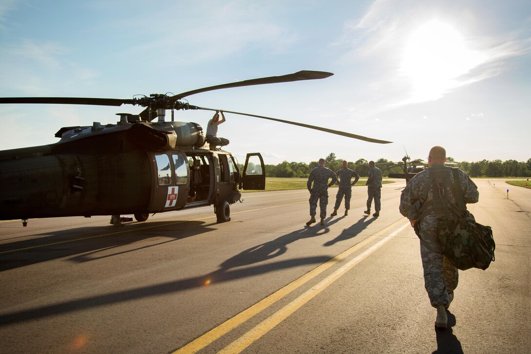Army 1st Sgt. Patrick Deuberry, right, approaches a UH-60 Black Hawk helicopter before participating in a flight mission during Warrior Exercise 86-16-03 at Fort McCoy, Wis., July 17, 2016. Deuberry is assigned to the Wisconsin Army National Guard’s Company F, 2nd Battalion, 238th General Support Aviation Battalion. The exercise is designed to keep soldiers all across the United States ready to deploy. Army photo by Sgt. Robert Farrell