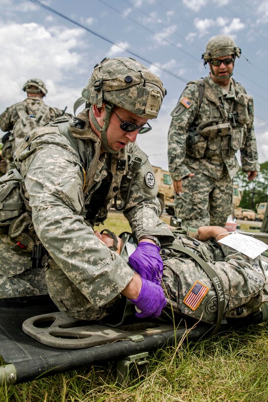 A soldier treats another soldier with a simulated back injury during a mass casualty exercise at the Joint Readiness Training Center, Fort Polk, La., July 16, 2016. The soldier perfoming the treatment is assigned to the New York Army National Guard's Headquarters Company, 1st Battalion 69th Infantry. Army National Guard photo by Sgt. Harley Jelis
