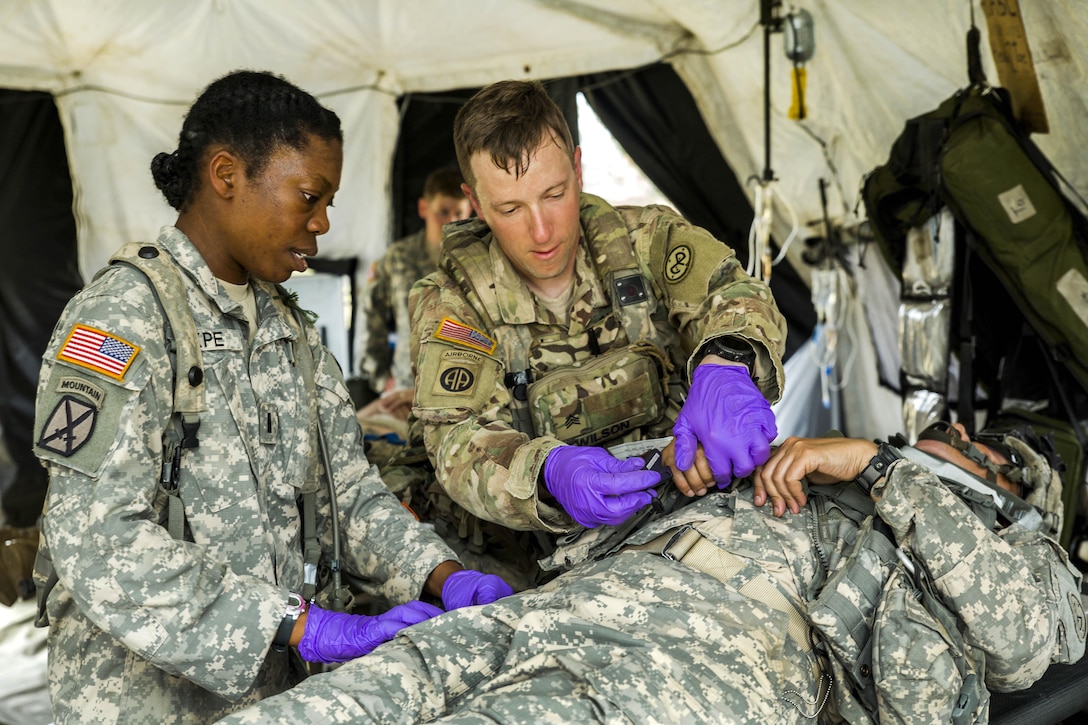 Army 1st Lt. Mercy Ukpe, left, and Army Sgt. Shawn Wilson provide medical care to a simulated casualty during a mass casualty exercise at the Joint Readiness Training Center, Fort Polk, La., July 16, 2016. Ukpe and Wilson are assigned to the New York Army National Guard's Headquarters Company, 1st Battalion 69th Infantry. Army National Guard photo by Sgt. Harley Jelis