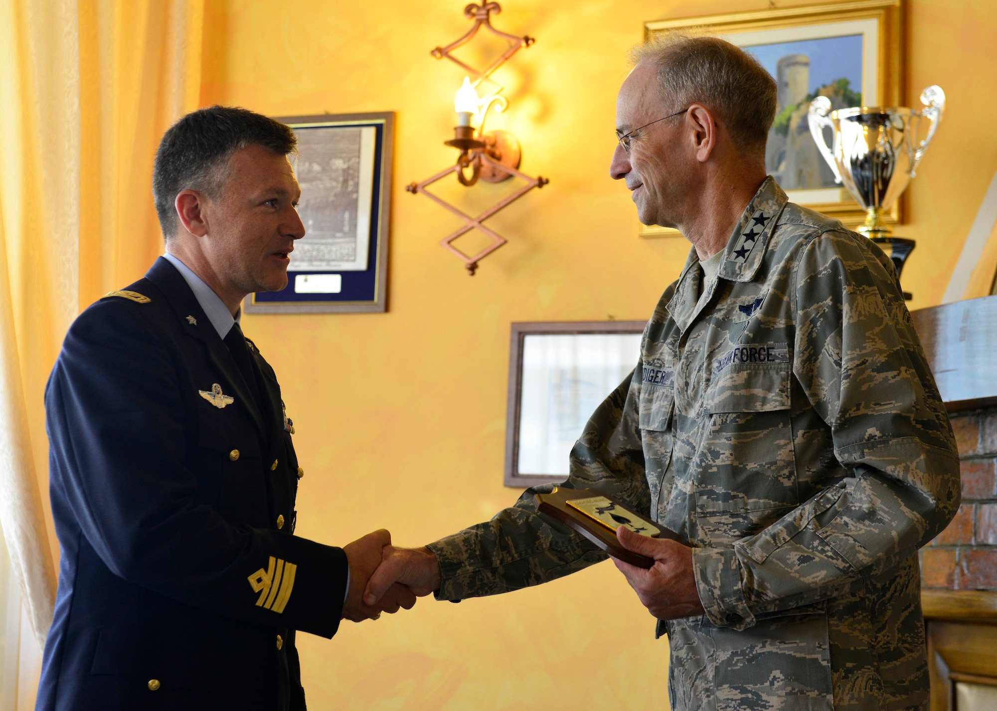 Italian air force Lt. Col. Francesco Mini, Comando Aeroporto Aviano chief of operations scheduling, presents Lt. Gen. (Dr.) Mark Ediger, Air Force Surgeon General, an appreciation plaque during Ediger’s visit, July 20, 2016, at Aviano Air Base, Italy. Ediger met with Italian flight surgeons and 31st Medical Group personnel to better understand their respective missions. (U.S. Air Force photo by Airman 1st Class Cary Smith/Released)