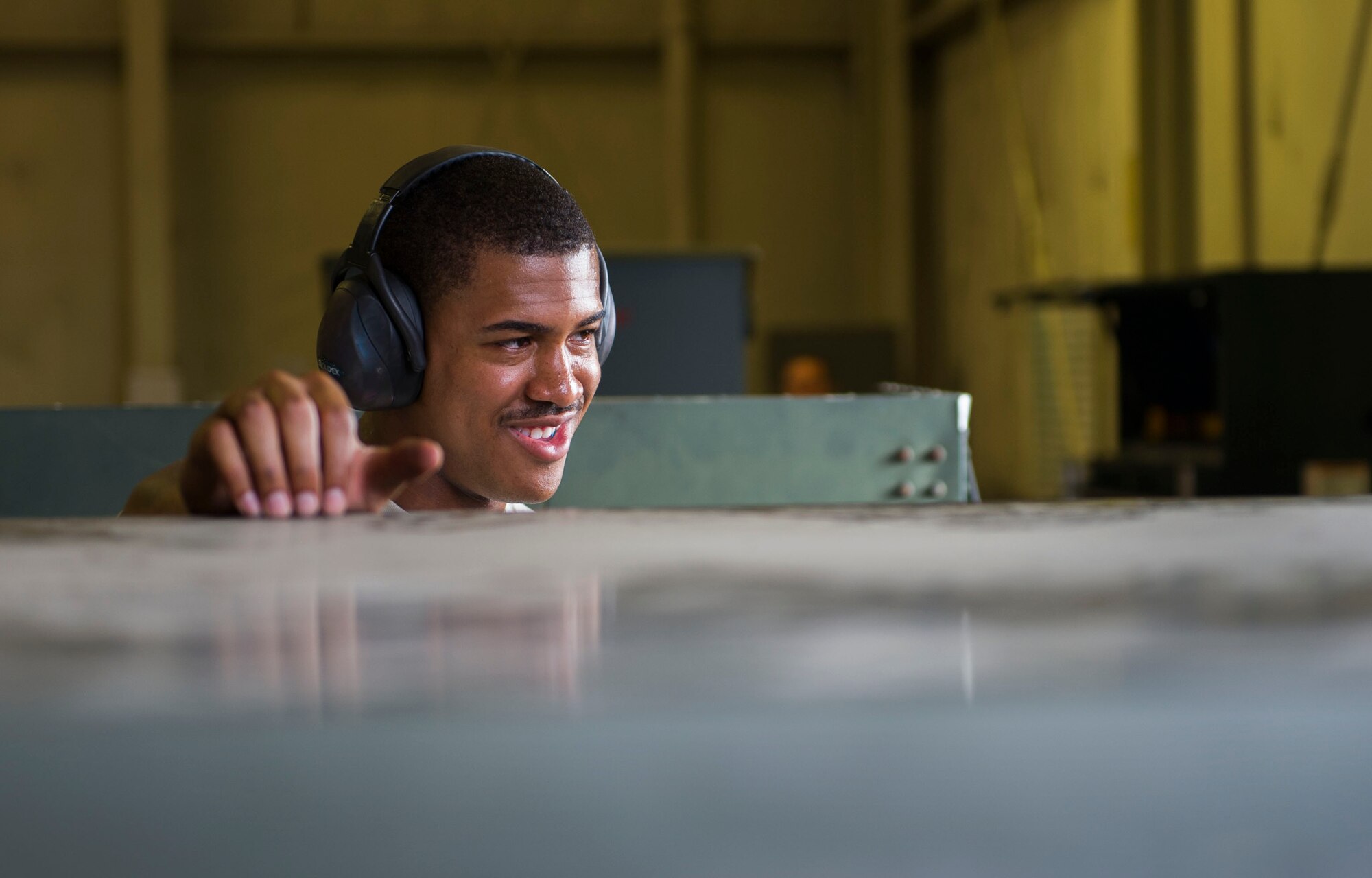 An aerospace ground equipment Airman from the 5th Maintenance Squadron talks with his coworker at Minot Air Force Base, N.D., July 20, 2016. AGE specialists maintain and repair equipment that supplies electricity, hydraulic pressure and air pressure to B-52H Stratofortresses at Minot AFB. (U.S. Air Force photo/Senior Airman Apryl Hall)