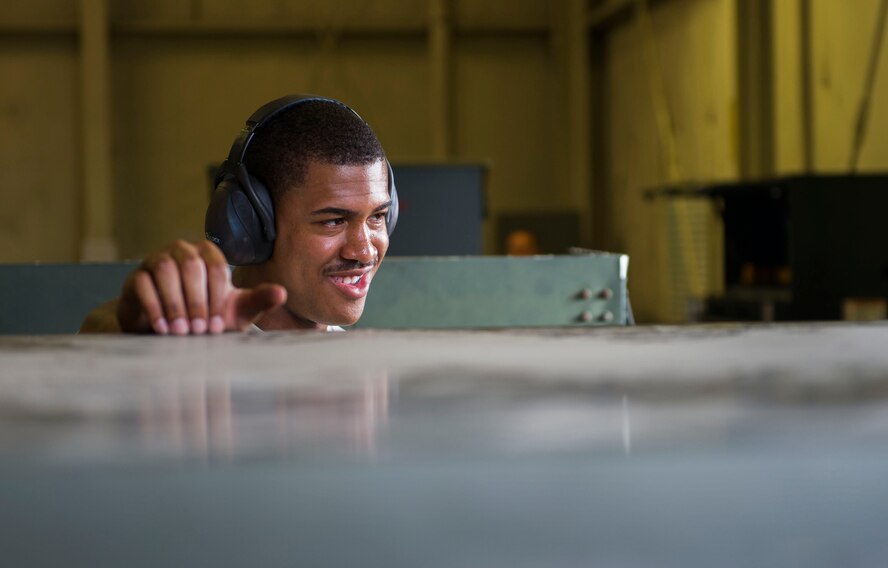 An aerospace ground equipment Airman from the 5th Maintenance Squadron talks with his coworker at Minot Air Force Base, N.D., July 20, 2016. AGE specialists maintain and repair equipment that supplies electricity, hydraulic pressure and air pressure to B-52H Stratofortresses at Minot AFB. (U.S. Air Force photo/Senior Airman Apryl Hall)