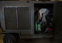 Senior Airman Avery Hale, 5th Maintenance Squadron aerospace ground equipment journeyman, works on an air conditioning unit at Minot Air Force Base, N.D., July 20, 2016. These units are used to keep temperatures down for maintainers on the flight line. (U.S. Air Force photo/Senior Airman Apryl Hall)
