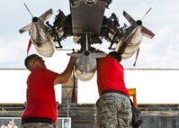 Airmen from the 23rd Aircraft Maintenance Unit load crew attach the final inert munition during the Load Crew of the Quarter competition at Dock 7 at Minot Air Force Base, N.D., July 22, 2016. The competition was comprised of four parts: dress and appearance, a loader’s knowledge test, toolbox inspection and the timed bomb load. (U.S. Air Force photo/Airman 1st Class J.T. Armstrong)