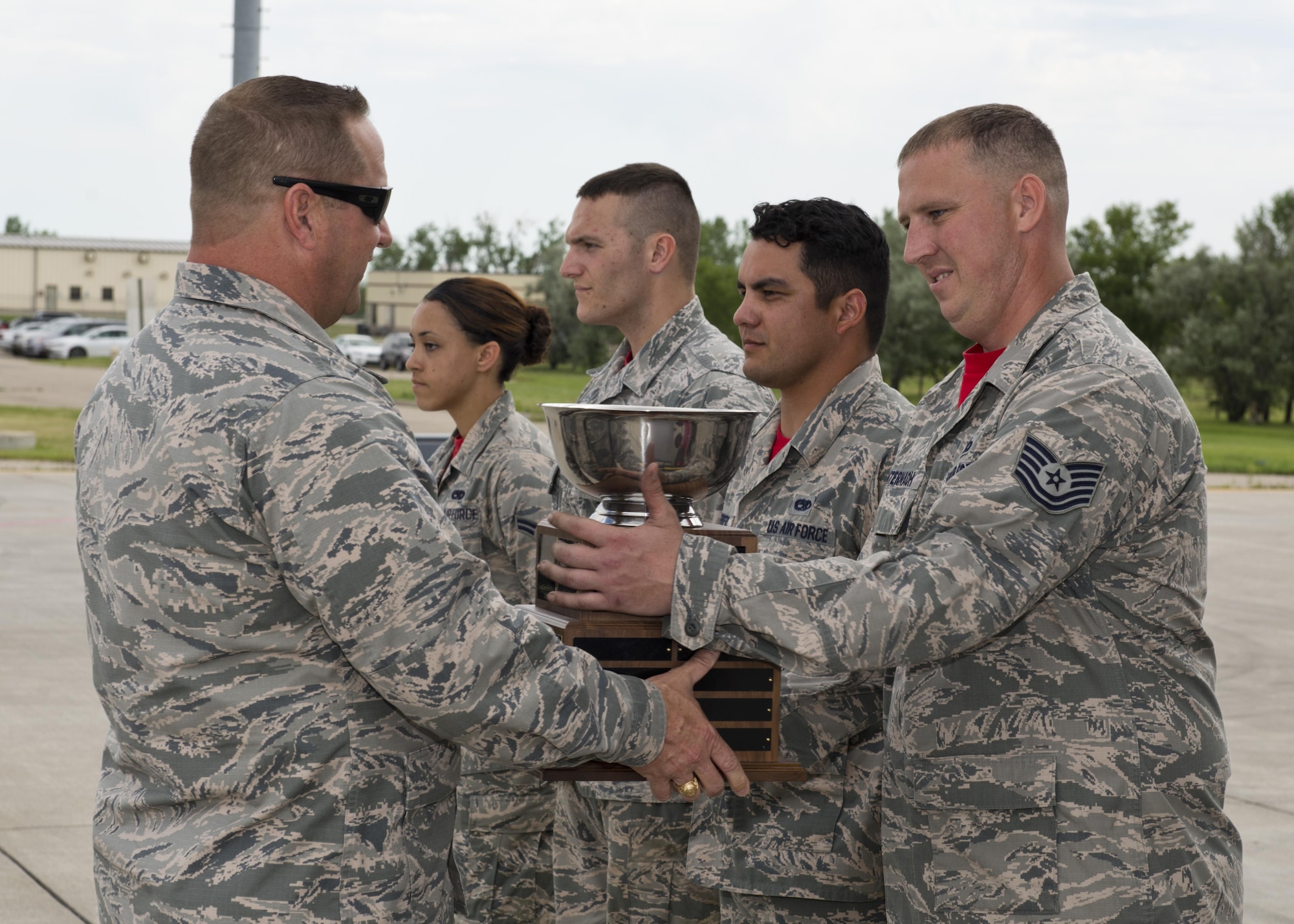 Airmen from the 23rd Aircraft Maintenance Unit are presented with the Load Crew competition trophy following the Load Crew of the Quarter competition at Minot Air Force Base, N.D., July 22, 2016. The competition was comprised of four parts: dress and appearance, a loader’s knowledge test, toolbox inspection and the timed bomb load. (U.S. Air Force photo/Airman 1st Class J.T. Armstrong)