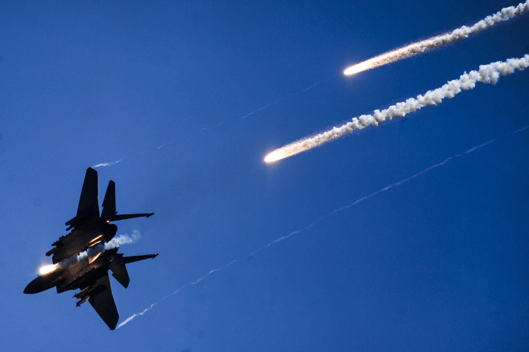 An F-15E Strike Eagle fires multiple flares during a Combined Arms Demonstration as part of the 2015 Wings Over Wayne Air Show, May 17, 2015, at Seymour Johnson Air Force Base, North Carolina. An aerial team of four Strike Eagles and two A-10 Warthogs joined forces to simulate taking over an airfield by eliminating enemy ground forces. (U.S. Air Force photo/Senior Airman Brittain Crolley)