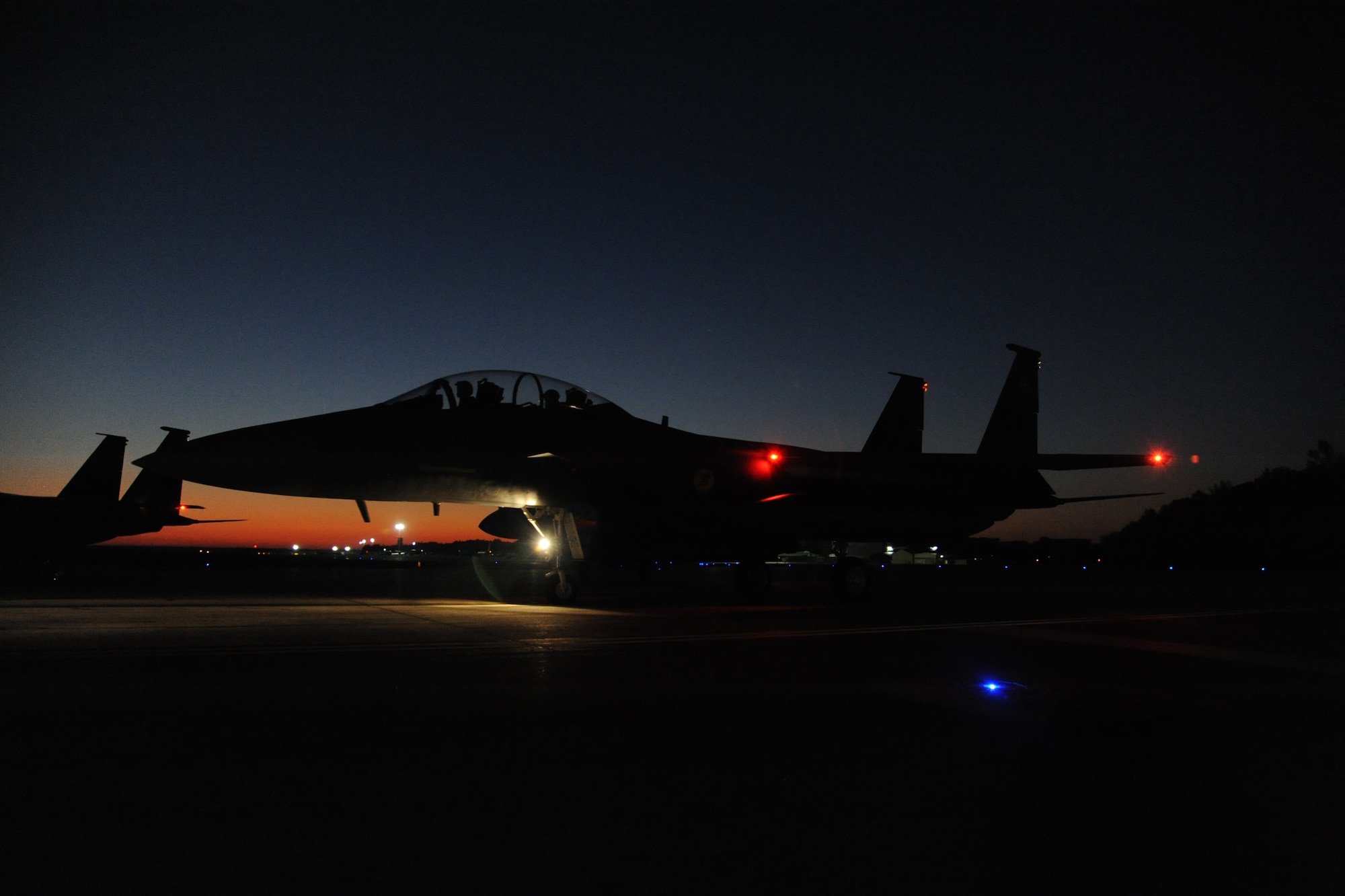 An F-15E Strike Eagle aircraft heads toward the end of the runway for takeoff on Seymour Johnson Air Force Base, N.C., Oct. 24, 2011. Aircrews are required to maintain flying currency during all hours of the day.  The F-15E is capable of engaging ground and air targets simultaneously, day or night, in all types of weather. (U.S. Air Force photo by Senior Airman Whitney Stanfield) 