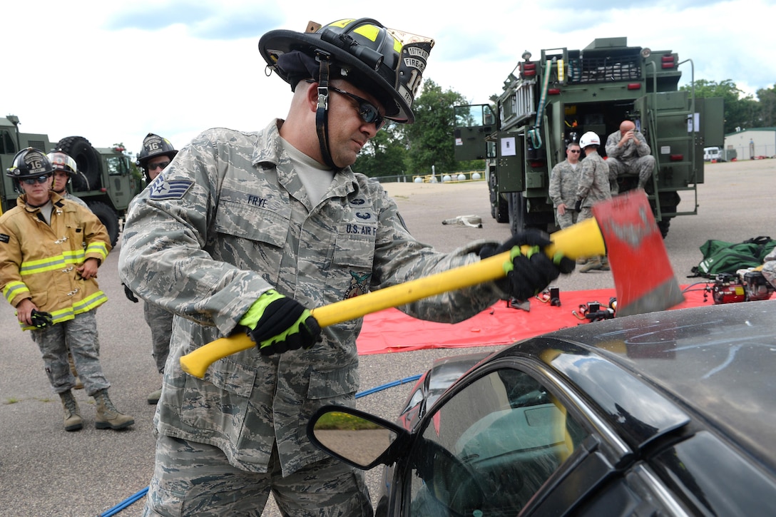 Air Force Staff Sgt. Michael Frye removes a car windshield with an ax during training to extricate passengers from vehicles as part of Patriot North 16 at Volk Field, Wis., July 16, 2016. The annual exercise helps the Guard develop working relationships with first responders and government agencies. Air National Guard photo by Senior Master Sgt. David H. Lipp