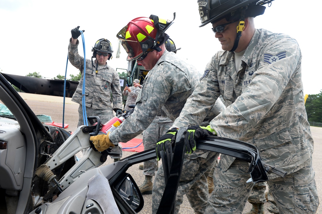 Air Force Staff Sgt. Michael Frye, right, holds a car door while Army Sgt. Somner Goecks operates a hydraulic tool and Air Force Staff Sgt. Joseph Ruppenthal holds hydraulic cables during vehicle extrication training as part of Patriot North 16 at Volk Field, Wis., July 16, 2016. Frye and Ruppenthal are firefighters assigned to the West Virginia Air National Guard’s 167th Civil Engineer Squadron. Goecks is a firefighter assigned to the 826th Ordnance Company. Air National Guard photo by Senior Master Sgt. David H. Lipp