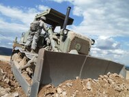 U.S. Army Reserve soldier, Spc. Juan Ayuso receives direction from Sgt. Nolanzo Lyles with the 766th Engineer Company (Horizontal), 841st Engineer Battalion, during an earth moving operation at Novo Selo Training Area, Bulgaria as part of Operation Resolute Castle 16, July 20, 2016. Ayuso, an electrician in his civilian career, stated he was excited to cross train since he normally uses a backhoe. “This is the best Extended Combat Training ever,” stated Ayuso. (U.S. Army photo by Capt. Jose F. Lopez Jr., 841st Eng. Bn., United States Army Reserve)