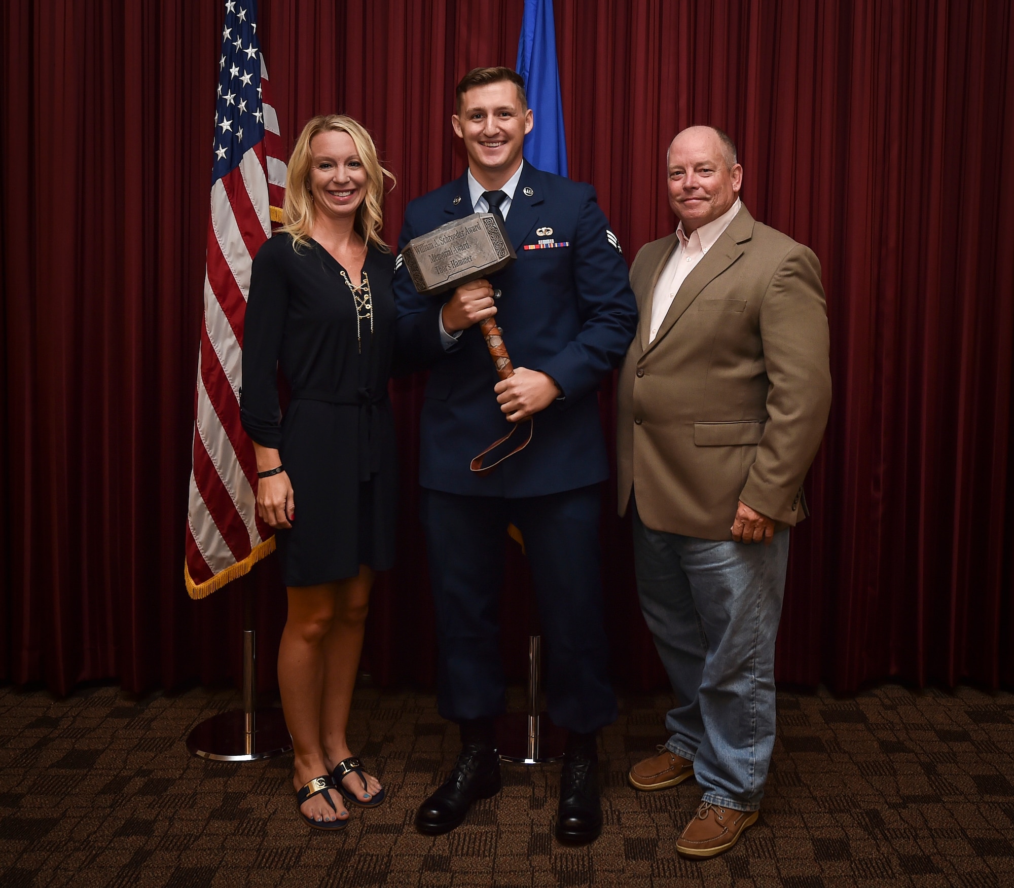 Senior Airman John Campbell, Special Operations Weather Team student assigned to the Special Tactics Training Squadron, accepts the first Lt. Col. William Schroeder Memorial Award from Abby Schroeder, Schoeder's widow, , and John Farris, a SOWT instructor with STTS, at Hurlburt Field, Fla., July 21, 2016. Schroeder served as a special operations weather officer and previously commanded the 10th Combat Weather Squadron here. He sacrificed his life when he was fatally shot protecting coworkers from a workplace violence incident at Joint Base San Antonio-Lackland, Texas. (U.S. Air Force photo by Senior Airman Ryan Conroy) 