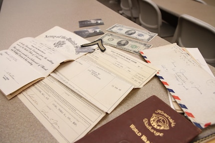 Donna Jones, planning director for Chenango County, reflects on her father's honorable discharge document from an aged-leather binder, old envelopes with handwritten letters to his mother, a ten-dollar bill described as a silver certificate, a twenty-dollar bill dated from 1934, Purple Heart medal, metal identification tags, pictures of him at 18-years-old, and an old patch with his rank of Private.  Jones personal connection to the military is what inspired her to help bring the Innovative Readiness Training event to the Greater Chenango Cares area.  Greater Chenango Cares is one of the IRT events that provide real-world training in a joint civil-military environment while delivering world-class medical care to the people of Chenango County, N.Y., from July 15-24.