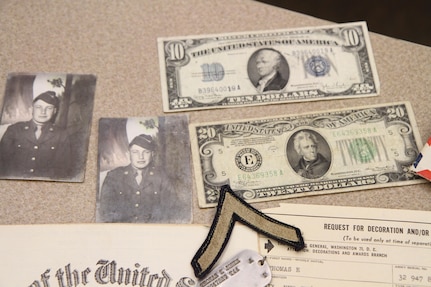 Donna Jones, planning director for Chenango County, reflects on her father's honorable discharge document from an aged-leather binder, old envelopes with handwritten letters to his mother, a ten-dollar bill described as a silver certificate, a twenty-dollar bill dated from 1934, Purple Heart medal, metal identification tags, pictures of him at 18-years-old, and an old patch with his rank of Private.  Jones personal connection to the military is what inspired her to help bring the Innovative Readiness Training event to the Greater Chenango Cares area.  Greater Chenango Cares is one of the IRT events that provide real-world training in a joint civil-military environment while delivering world-class medical care to the people of Chenango County, N.Y., from July 15-24.