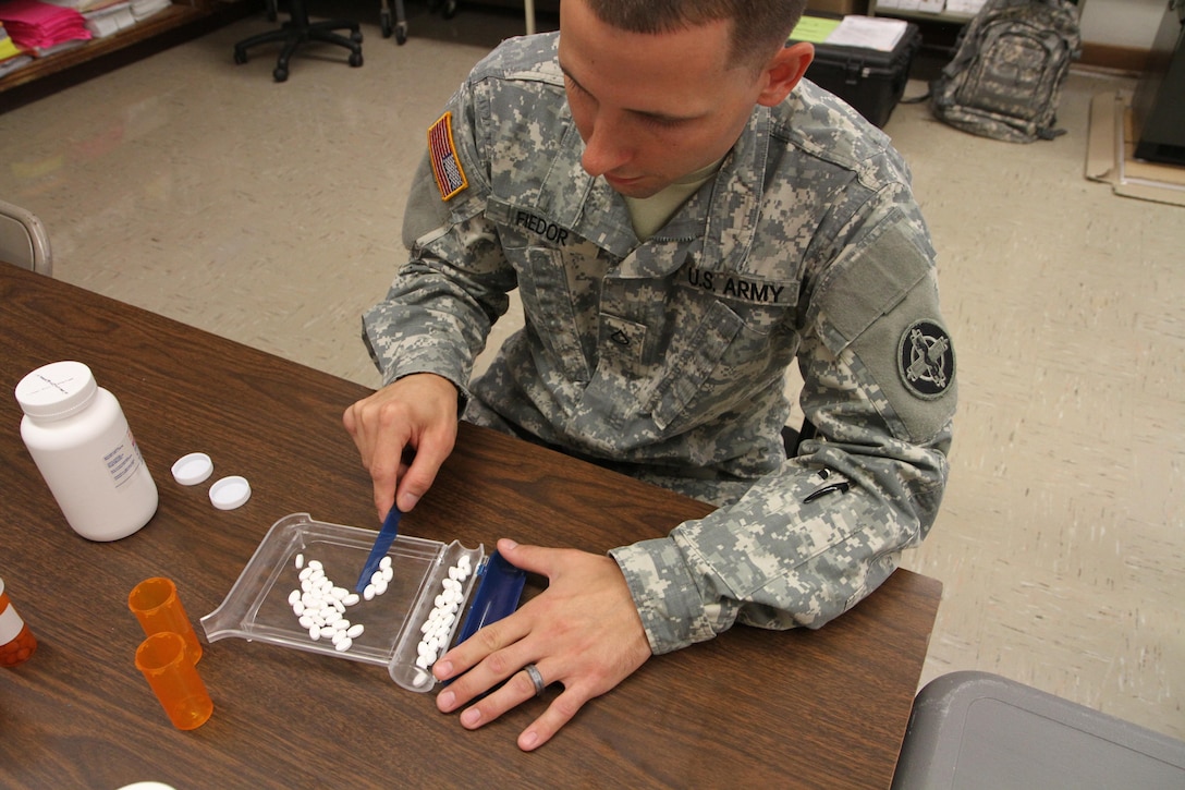 Pfc. Michael Fiedor, a pharmacy technician from Alpha Company, 48th Combat Support Hospital out of Fort Meade, Md., counts pills to fill a prescription during the Greater Chenango Cares Innovative Readiness Training event, July 20, 2016.  Greater Chenango Cares is one of the IRT events that provides real-world training in a joint civil-military environment while delivering world-class medical care to the people of Chenango County, N.Y., from July 15-24.