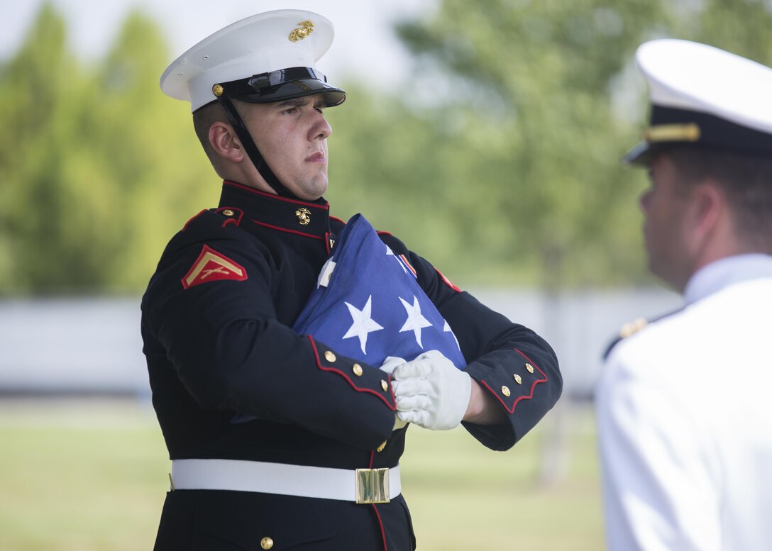 A Marine Corps Body Bearer prepares to deliver the national flag during a funeral at Arlington National Cemetery, Va., July 20, 2016. The Marine Corps Body Bearers have the solemn and honorable duty to lay the Corps’ brothers and sisters to rest at the hallowed grounds of Arlington National Cemetery and other locations throughout the National Capital Region. (Official Marine Corps photo by Lance Cpl. Robert Knapp/Released)