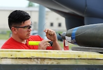 An Airmen from the 23rd Aircraft Maintenance Unit inspects an inert munition during the Load Crew of the Quarter competition at Dock 7 at Minot Air Force Base, N.D., July 22, 2016. Two weapons load crews, representing the Bomb Squadron, were timed on their ability to load three inert munitions onto a B-52H Stratofortress. (U.S. Air Force photo/Senior Airman Kristoffer Kaubisch)