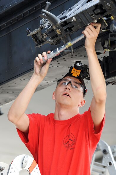 An Airmen from the 23rd Aircraft Maintenance Unit load crew prepares to attach an inert munition during the Load Crew of the Quarter competition at Dock 7 at Minot Air Force Base, N.D., July 22, 2016. Two weapons load crews, representing the 23rd Bomb Squadron, were timed on their ability to load three inert munitions onto a B-52H Stratofortress. (U.S. Air Force photo/Senior Airman Kristoffer Kaubisch)